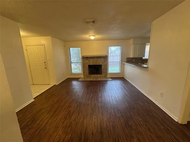 a view of a livingroom with wooden floor a fireplace and window