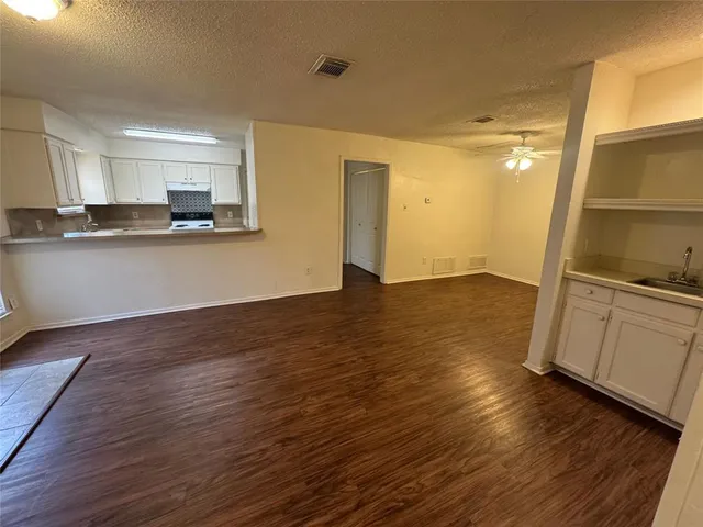 a view of a kitchen with wooden floor and electronic appliances