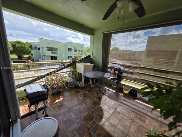 a living room with patio furniture and a floor to ceiling window