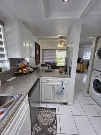a kitchen with a sink a stove a microwave cabinets and a dining table