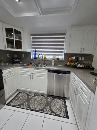 a kitchen with a sink a stove and cabinets