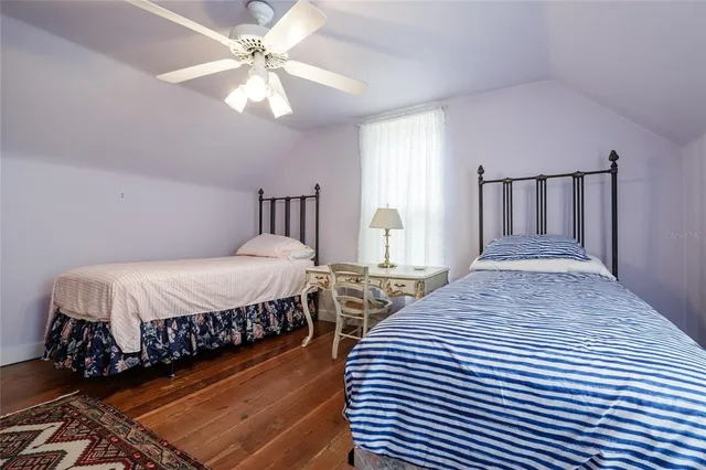 a kitchen with refrigerator and wooden floor