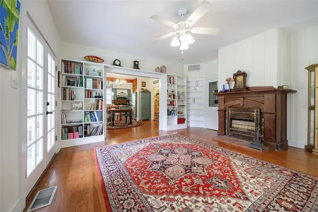 a living room with a couch bookshelf and a fireplace