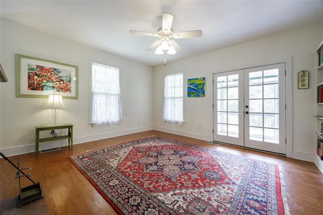 an empty room with windows and ceiling fan