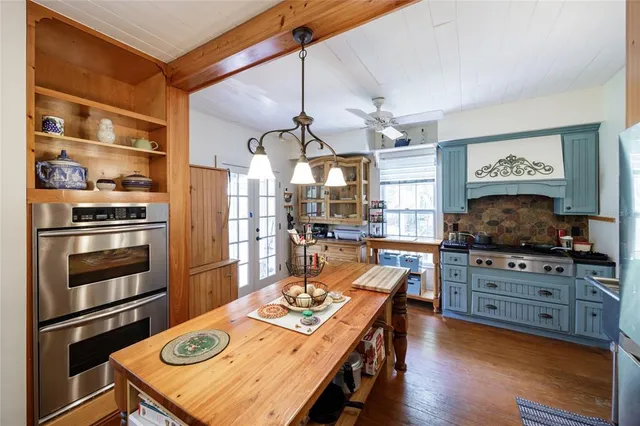 a kitchen with stainless steel appliances kitchen island granite countertop a refrigerator a stove and a sink with dishwasher