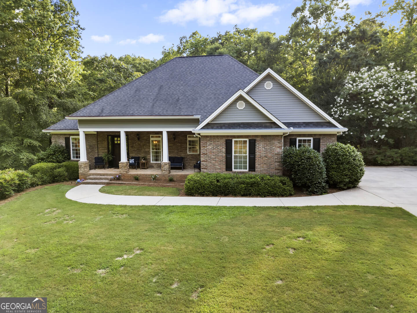 a view of a house with a yard potted plants and large tree