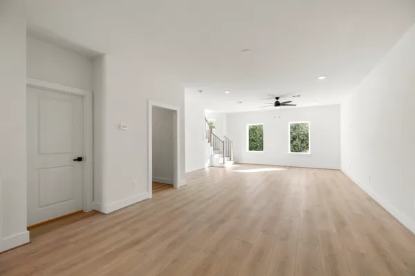an empty room with wooden floor and windows