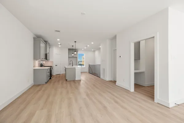 a view of a kitchen with a sink and dishwasher a refrigerator with wooden floor