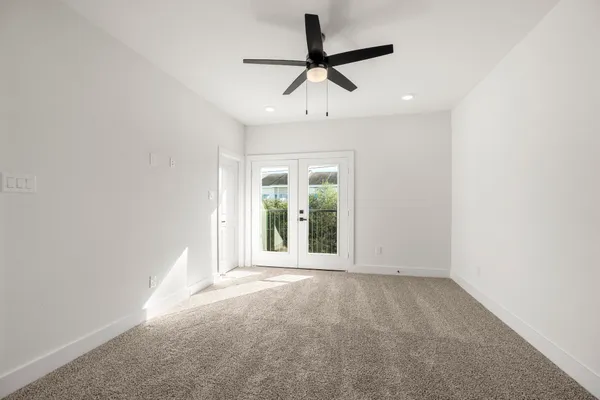 an empty room with a ceiling fan and window