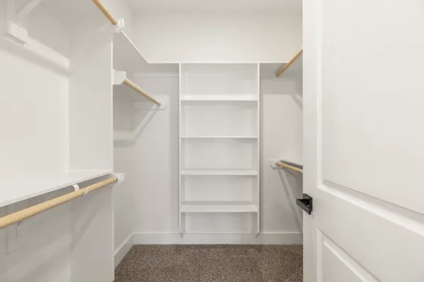 a view of walk in closet with empty racks