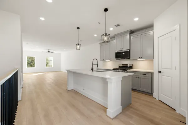 a large white kitchen with stainless steel appliances