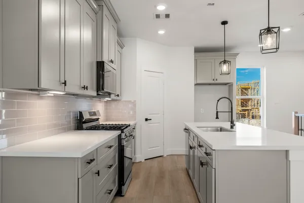 a kitchen with kitchen island granite countertop a sink stainless steel appliances and cabinets
