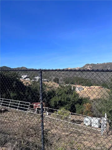 a view of a yard with wooden fence