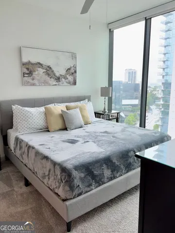 a bedroom with a large bed and a painting on the wall