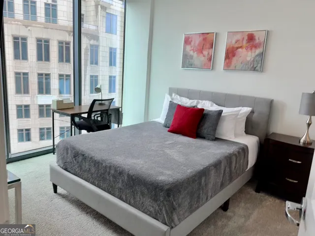 a bed sitting in a bedroom next to a large window