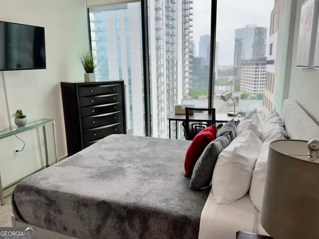 a bedroom with a bed and dresser with mirror