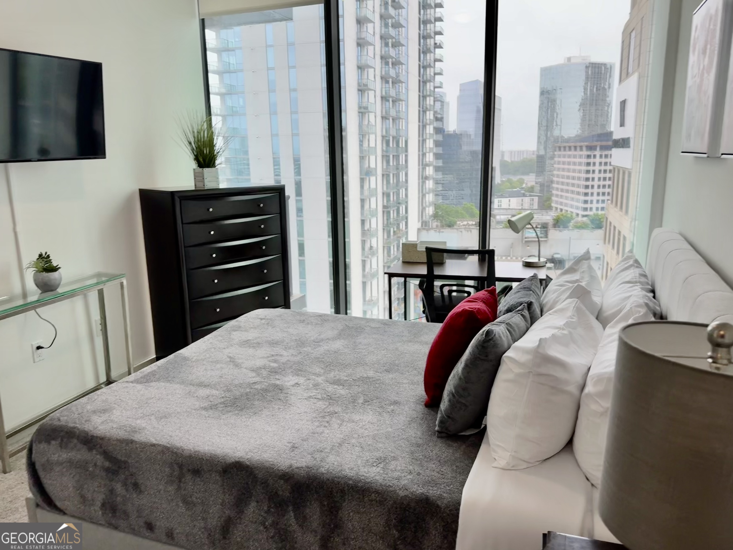 3382 Peachtree Road, Unit S12 Atlanta, GA 30326 - Photo 22 of 47 a bedroom with a bed and dresser with mirror