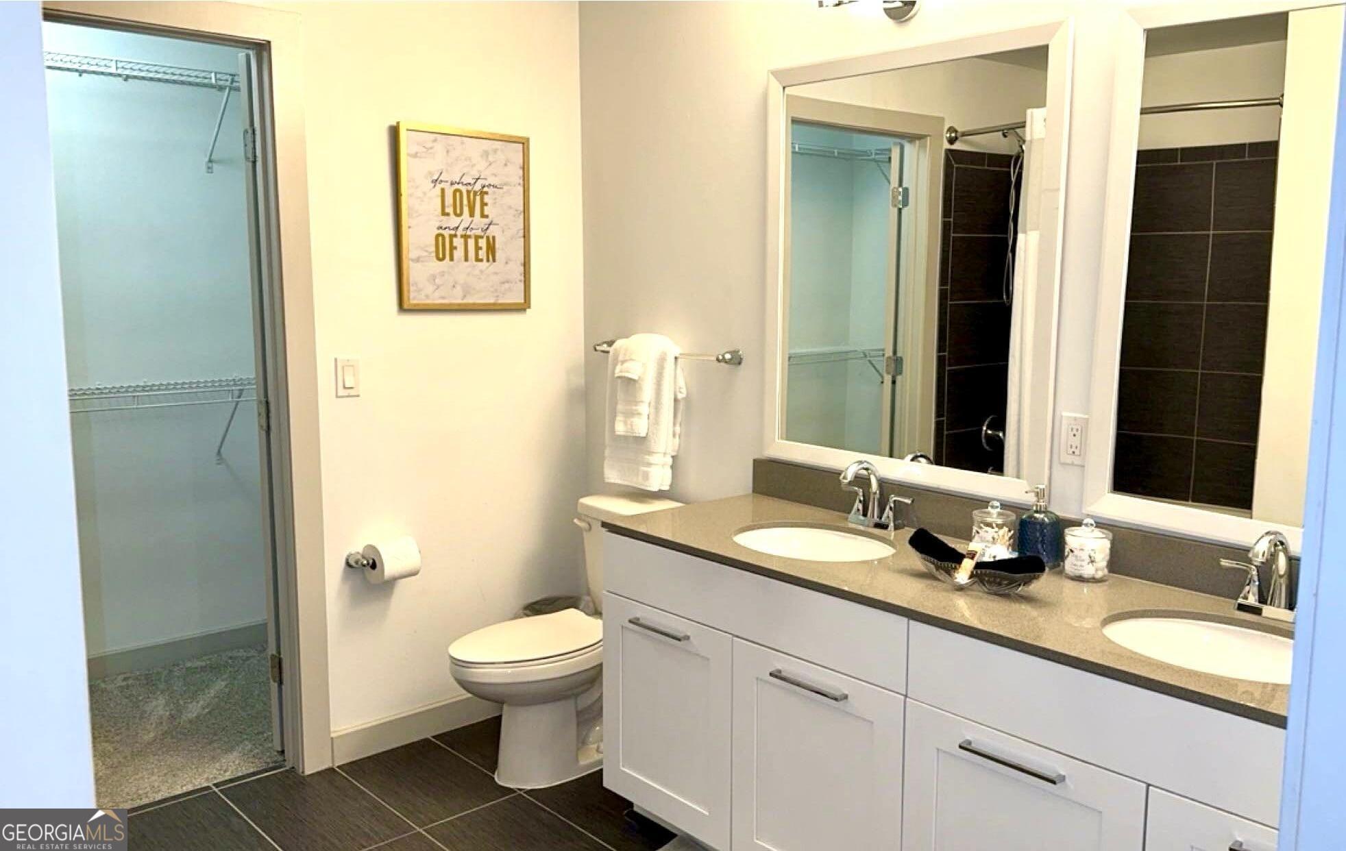 3382 Peachtree Road, Unit S12 Atlanta, GA 30326 - Photo 27 of 47 a bathroom with a granite countertop sink toilet a large mirror a shower and a mirror