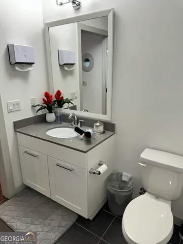 a bathroom with a toilet sink and mirror
