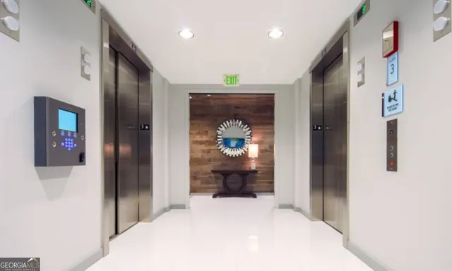 a view of a hallway with wooden floor and a living room