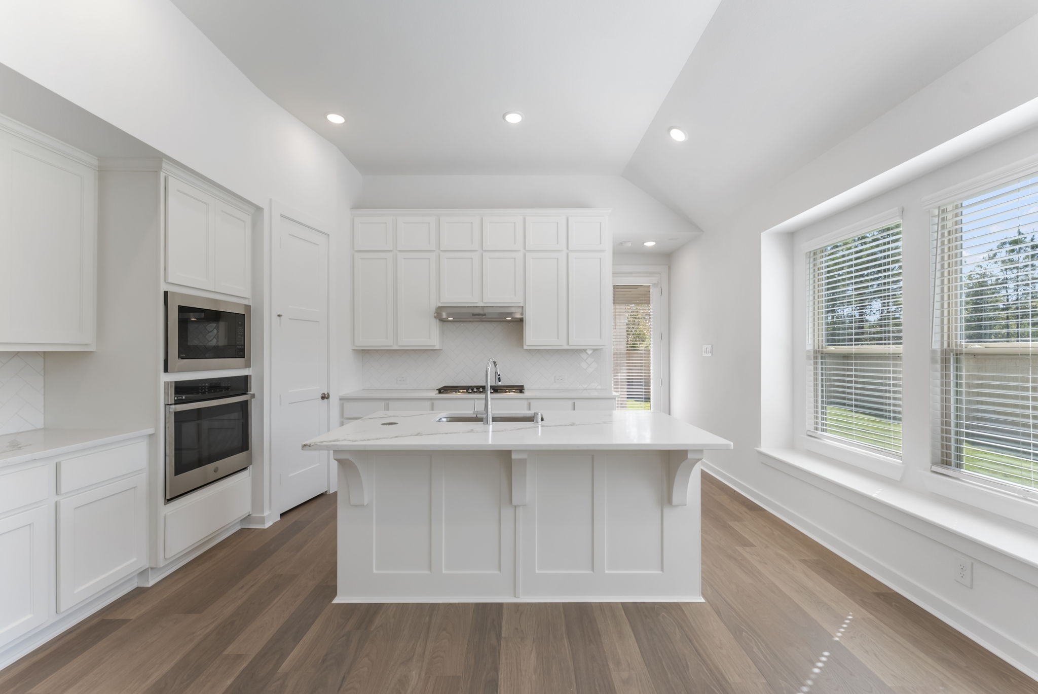 a kitchen with stainless steel appliances a sink stove and cabinets