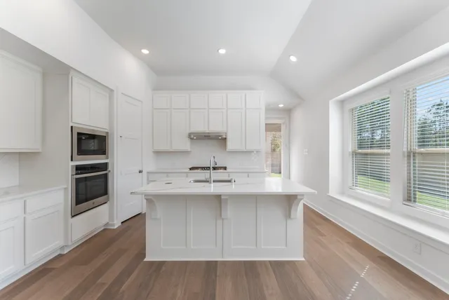 a kitchen with stainless steel appliances a sink and cabinets