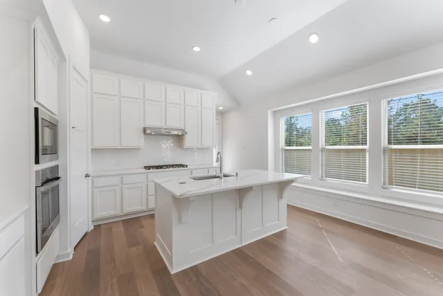 a kitchen with stainless steel appliances kitchen island granite countertop a sink and cabinets