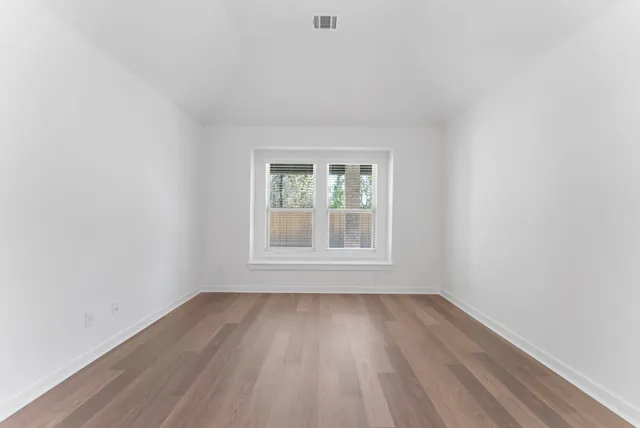 a view of an empty room and wooden floor