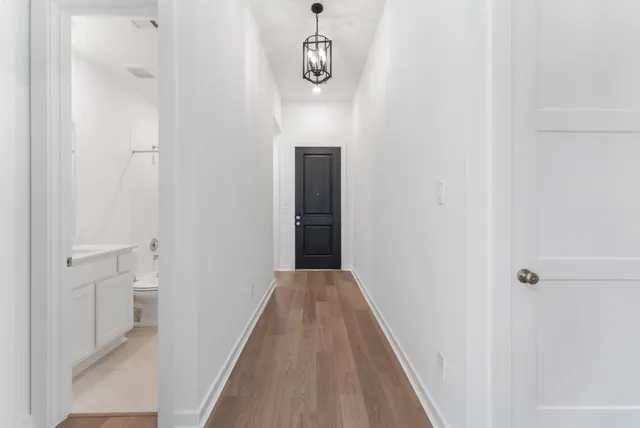a view of a hallway with wooden floor and staircase