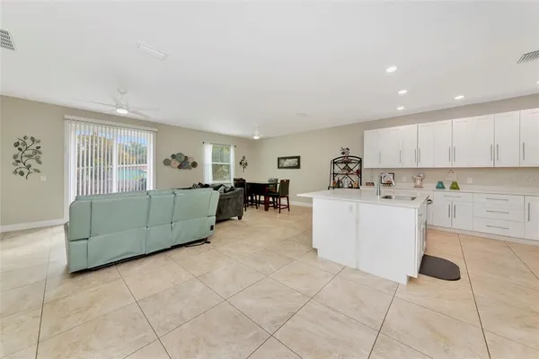 a living room with furniture and a refrigerator