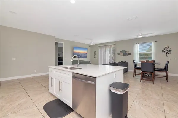 a kitchen with a sink a stove a refrigerator and chairs