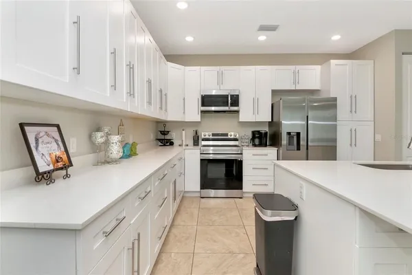 a kitchen with stainless steel appliances a refrigerator sink and microwave