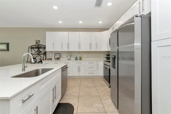 a kitchen with white cabinets sink and stainless steel appliances