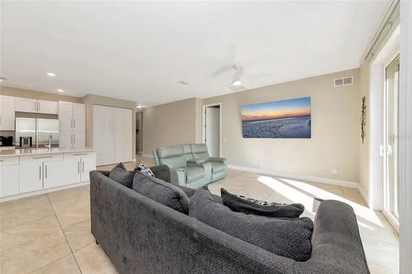 a living room with furniture and view of kitchen