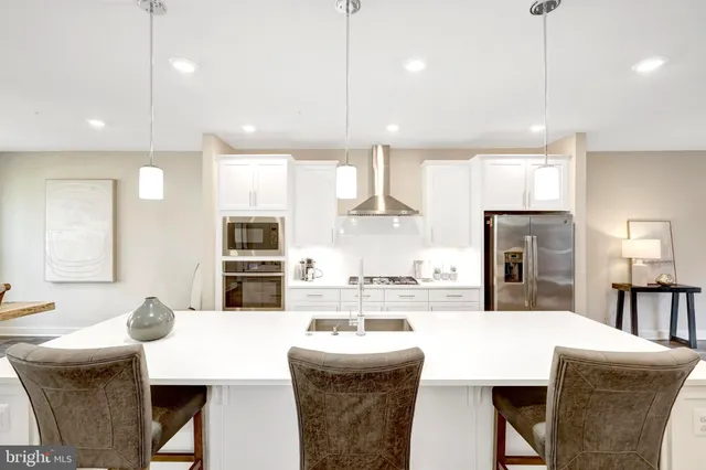 a large kitchen with kitchen island a dining table and chairs