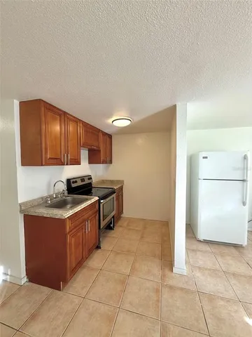 a kitchen with stainless steel appliances granite countertop a stove a refrigerator and a sink