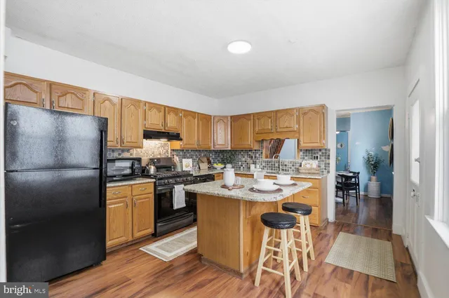 a kitchen with a sink a stove cabinets and a dining table