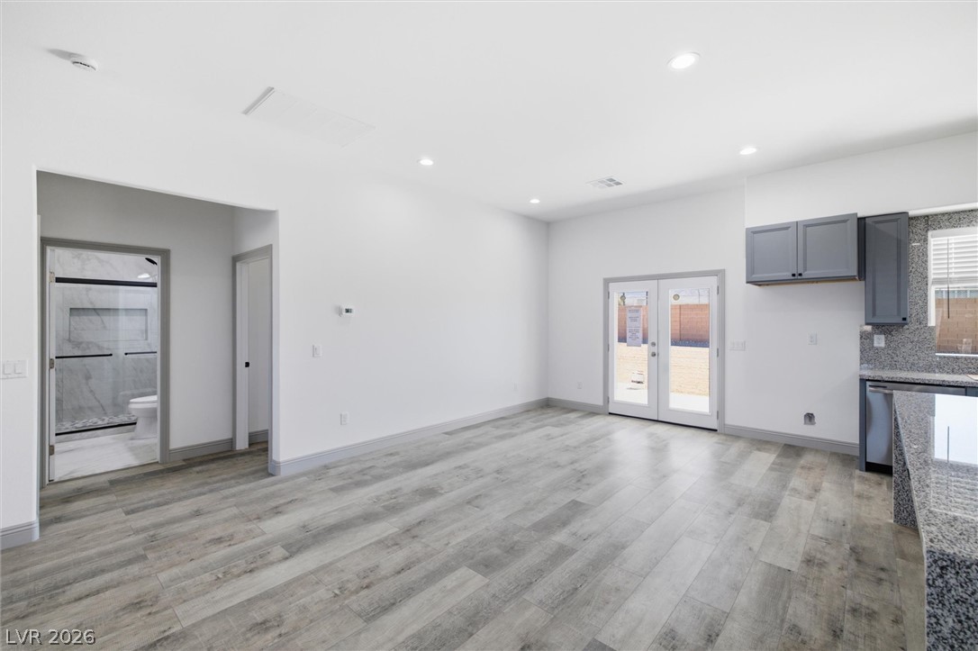 1061 Factory Road Pahrump, NV 89048 - Photo 9 of 41 A well-lit living area features modern wood-look tile flooring and glass doors opening to a private yard.