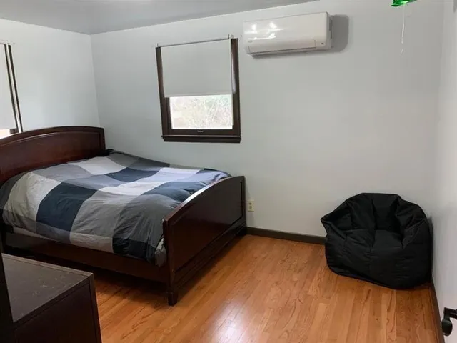 a bedroom with a bed and wooden floor