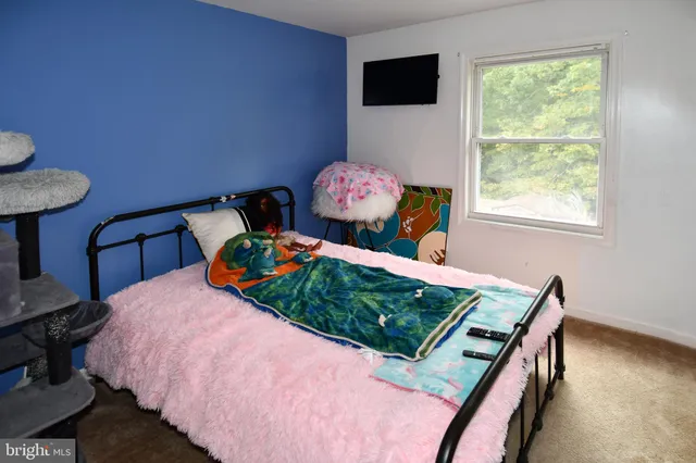 a bed sitting in a bedroom next to a window