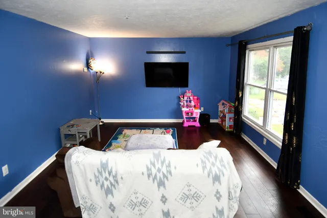a bedroom with a bed and a flat tv screen on dresser