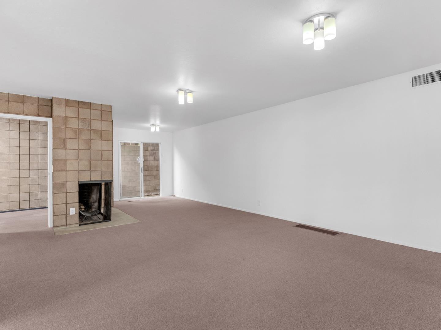 224 Olympian Way Pacifica, CA 94044 - Photo 16 of 46 an empty room with fireplace and windows