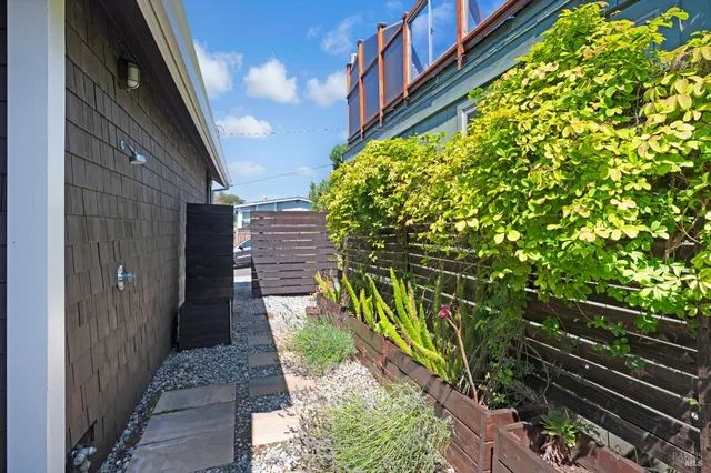 a balcony with wooden floor and outdoor seating