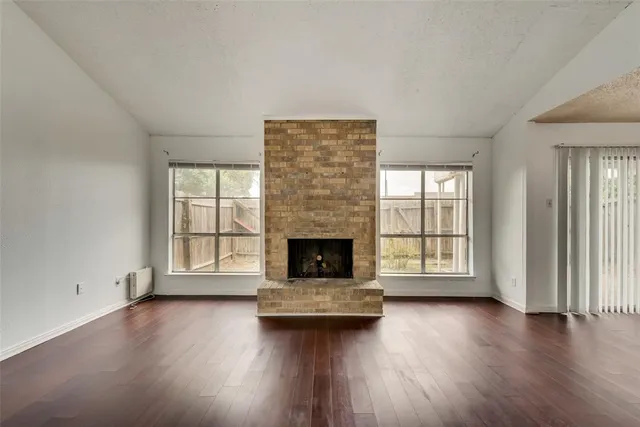 an empty room with floor to ceiling window and fireplace