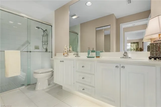 a bathroom with a double vanity sink a toilet and a mirror