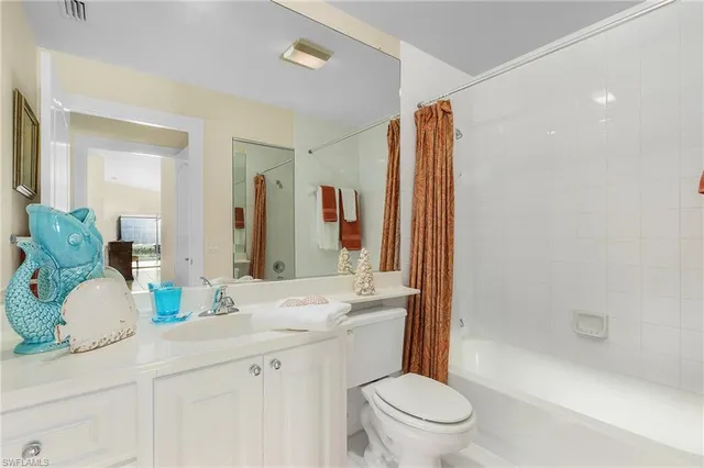 a bathroom with a granite countertop sink mirror vanity and toilet