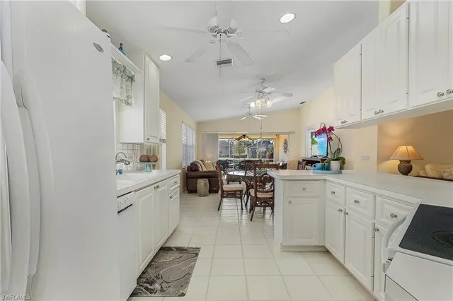 a kitchen with white cabinets and white appliances
