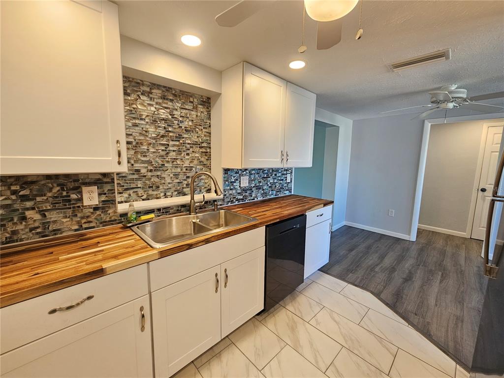 8229 Cypress Road Englewood, FL 34224 - Photo 11 of 44 a kitchen with a sink and cabinets