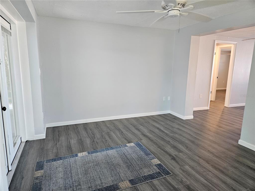 8229 Cypress Road Englewood, FL 34224 - Photo 16 of 44 an empty room with wooden floor closet and windows
