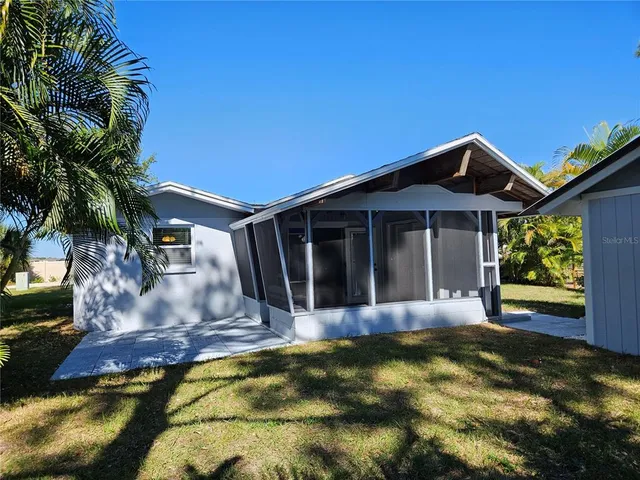 a view of swimming pool with lawn chairs and plants